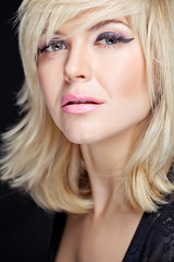 Naklejka premium Portret seksowna blondynka w studiu, czarne tło