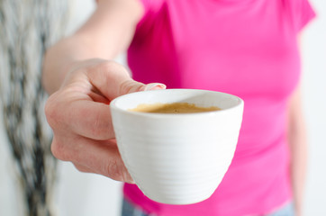 Woman showing a cup of coffee