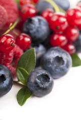 Many blueberries, raspberries. Isolated white