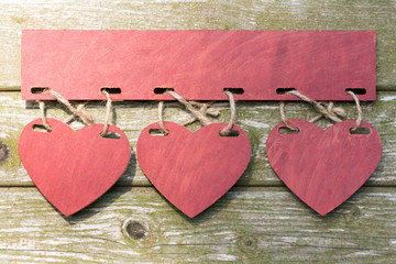 Drei Herzen vor Holz