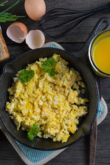 scrambled eggs with toast, top view on wooden table
