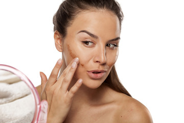 woman apply different shades of liquid foundation on her face