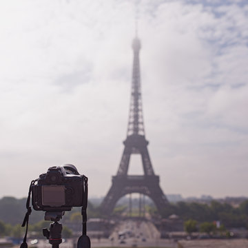 Camera on tripod pointing Eiffel Tower in Paris, France.