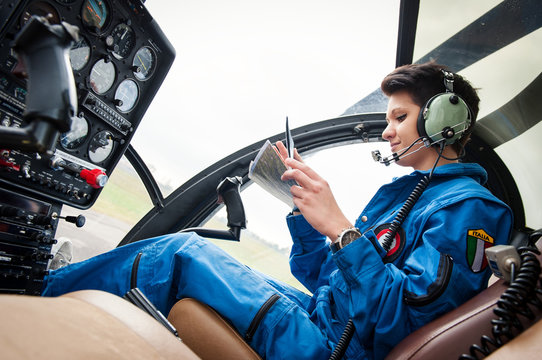 Young woman helicopter pilot reading map.