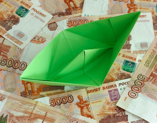 Green paper boat on five thousand rubles banknotes