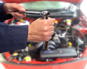 Hand of car mechanic with wrench.