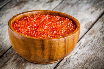 fresh red caviar in a wooden bowl