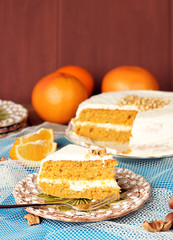 Carrot cake on a wooden table with oranges