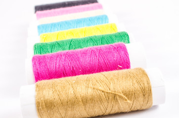 multicolor sewing threads on white background,