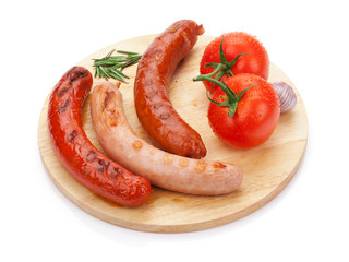 Various grilled sausages with condiments and tomatoes