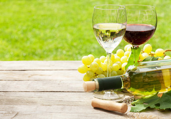 White and red wine glasses, wine bottle and white grape