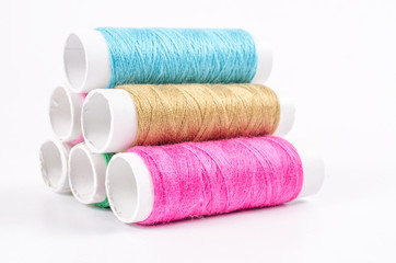 multicolor sewing threads on white background,