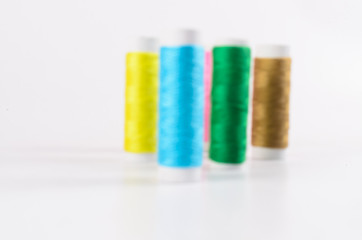 multicolor sewing threads on white background,