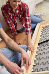 close up of couple assembling furniture at home
