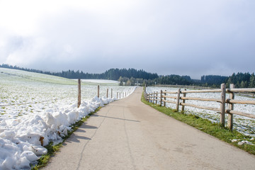 Cold winter day at countryside. Road and wooden fence.