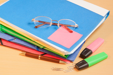 Group of multicolored office folders, glasses and office supplie