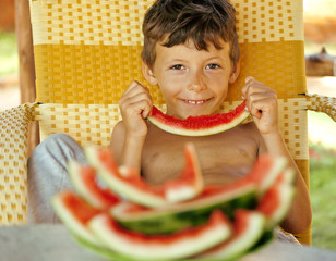 cute young little boy with watermelon crustes smiling