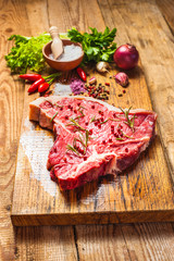 Close-up of fresh meat steak with spices on wooden background