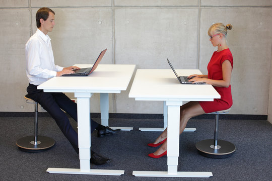 Business people - co workers in correct sitting posture at desks