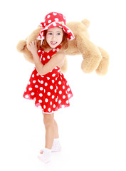 Fashionable little girl is on the shoulder of a teddy bear