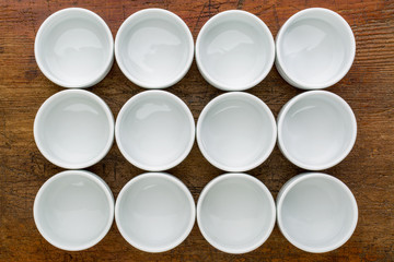dozen of empty white tasting bowls