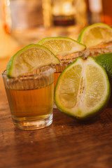 tequila , lime and salt on wooden table