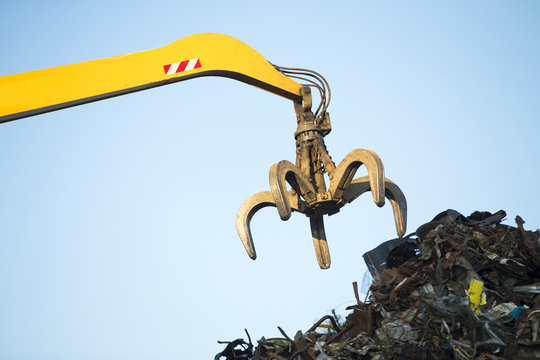 Large tracked excavator working a steel pile at a metal recycle