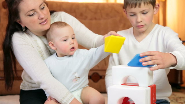 Mother and children playing with colored blocks