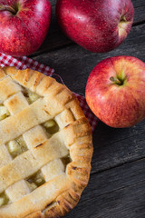 Apple pie and fresh apples on table