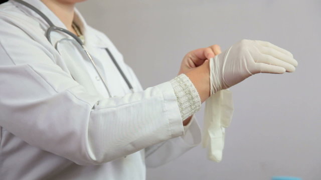 Doctor putting on gloves before examining the patient