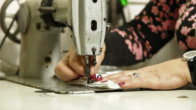 Professional tailor  using sewing machine in workshop