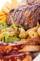 Platter of mixed meats, salad and French fries