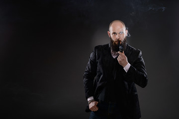 Bearded bald elegant man smoking a pipe