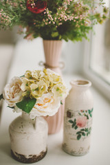 Spring flowers in retro vases on windowsill