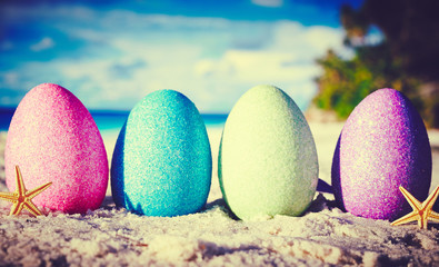Colorful easter eggs on ocean beach – retro style