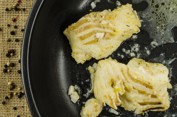 White cod on black frying pan