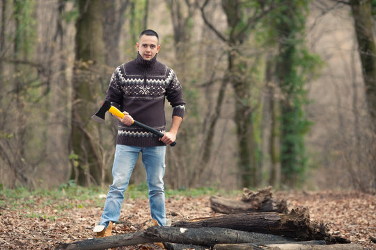 Young lumberjack holding an axe preparing to cut the tree