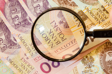 Polish zloty banknotes currency and magnifying glass