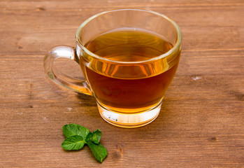 Tea with mint on cup on wooden table