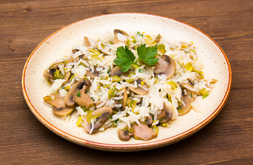 Mushroom risotto on the plate on wooden table