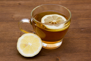 Tea with lemon on cup on wooden table