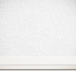 Empty white wooden table over white cement wall background