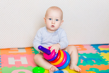 Cute little baby playing with colorful toys