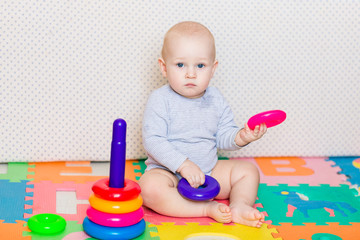 Cute little baby playing with colorful toys