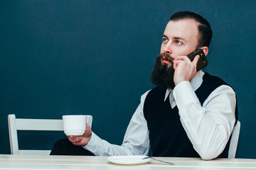 Businessman drinking coffee and talking on the phone.