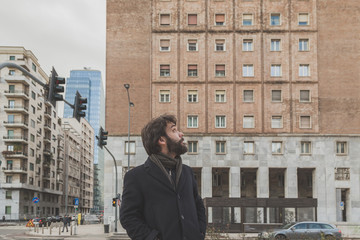 Young handsome bearded man posing in the city streets