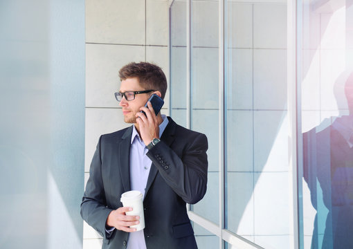 urban attractive businessman with phone device and coffee on off