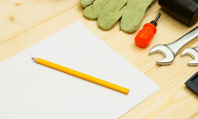Paper for notes and set of working tools on wooden background.