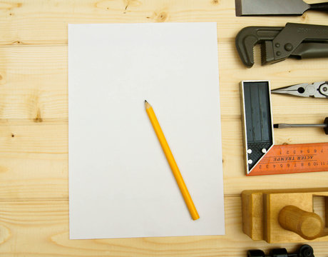Paper for notes and set of working tools on wooden background.