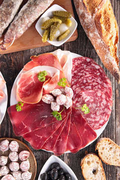 plate of meats with olive and bread